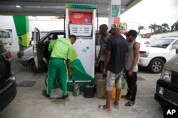 FILE - People queue at a petrol station in Lagos, Nigeria, Feb. 18, 2022. A prolonged fuel shortage in Nigeria, Africa's top crude oil producer, has provoked growing frustration.