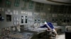 FILE - An employee is seen in a control center of one of the stopped reactors at the Chernobyl Nuclear Power Plant in Chernobyl, Ukraine, March 25, 2021. 