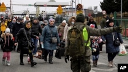 A Polish border guard guides people at the Ukrainian-Polish border crossing in Korczowa, Poland, March 5, 2022.