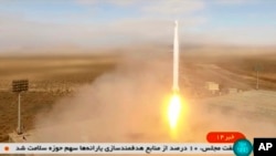 Potongan gambar dari video yang disiarkan oleh televisi pemerintah Iran menunjukkan peluncuran roket oleh Pasukan Revolusi Iran di timur laut gurun Shahroud, Iran, pada 8 Maret 2022. Roket tersebut membawa satelit Noor-2 . (Foto: Iranian state television via AP)