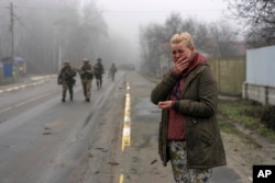 Mariya Ol'hovs'ka, 33, mourns the dead of her father Valerii Ol'hovs'kyi, 72, killed by a Russian missile on March 30 near his house in the outskirts of Kyiv, Ukraine, April 1, 2022.