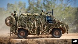 FILE - In this photo provided by the Australian Defense Force, an Australian Army Bushmaster armored vehicle moves off road during a training mission July 7, 2021, in Townsville, Australia. 