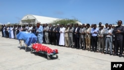 Political leaders pray in front the two bodies of the local lawmakers including Amina Mohamed Abdi after being airlifted from Beledweyne, at Aden Adde International Airport in Mogadishu, Somalia, on March 24, 2022.
