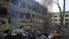 A car burns at the site of a maternity hospital heavily damaged by an airstrike, in Mariupol, Ukraine, March 9, 2022.