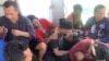 Pekerja migran asal Indonesia tampak terduduk lemas di kapal milik tim SAR setelah berhasil diselamatkan dari laut di Sumatra Utara ketika feri yang mereka tumpangi tenggelam pada 19 Maret 2022. Feri tersebut hendak bergerak menuju Malaysia. (Foto: Handout/Search and Rescue/AFP)