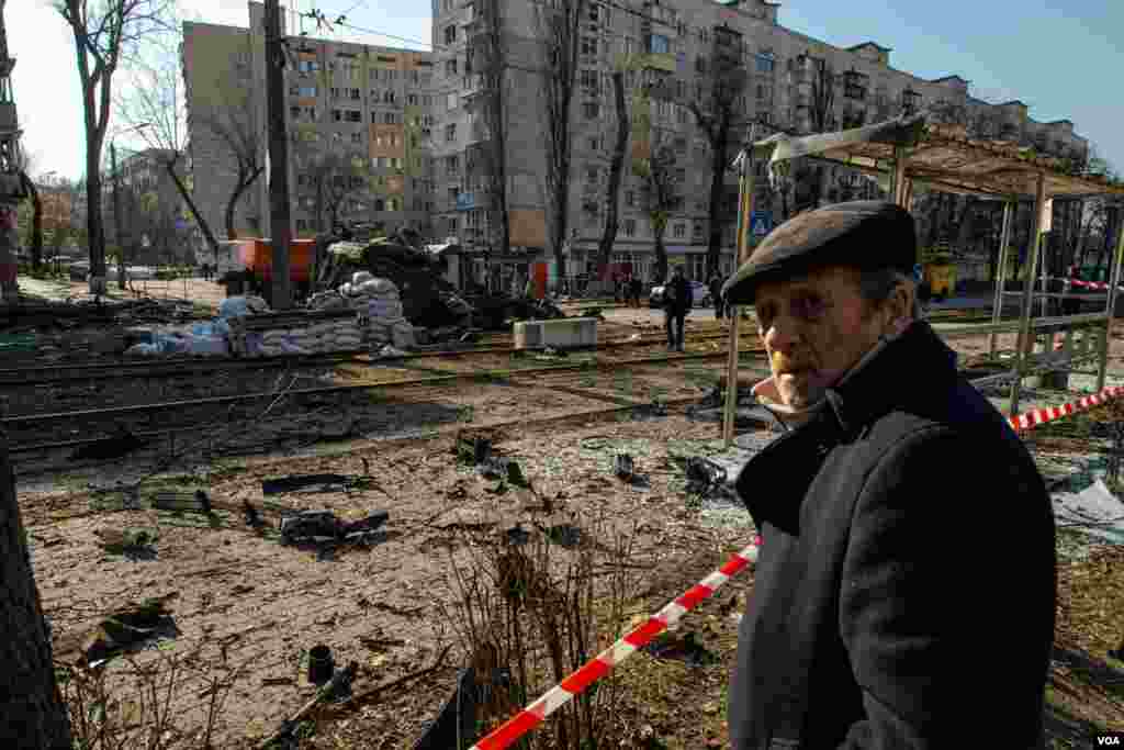 A man examines a wrecked streetcar that was struck by a missile in Kyiv, Ukraine, March 14, 2022. 