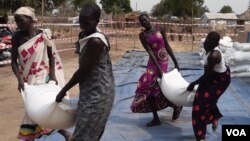 Displaced people in Bor, South Sudan, collect food aid last month. The conflict in Ukraine and resulting sanctions on Russia are driving up global oil and food prices, which could lead to increased hunger in Africa, analysts say. (Kate Bartlett/VOA)