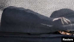 FILE - A woman looks through a tent during a gathering by Houthi loyalists against Saudi-led airstrikes in Yemen's capital Sanaa, March 9, 2016.