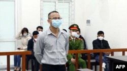 This picture taken and released by the Vietnam News Agency shows Vietnamese activist Le Van Dung in a courtroom during his trial in Hanoi, March 23, 2022, as he was sentenced to 5 year in jail. 