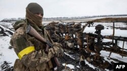 Binh sĩ Ukraine xem xét các xe quân sự bị phá hủy, ảnh do quân đội Ukraine công bố hôm 8/3, không nêu địa điểm. 