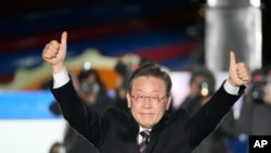 Lee Jae-myung, the presidential candidate of the ruling Democratic Party, raises his hands during a presidential election campaign in Seoul, South Korea, March 8, 2022. 