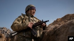 Un militaire ukrainien se tient dans une tranchée au nord de la capitale Kiev, Ukraine, le 29 mars 2022. 