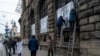 FILE - People cover the windows Museum of Ethnography with metal plates in Lviv, western Ukraine, March 2, 2022.