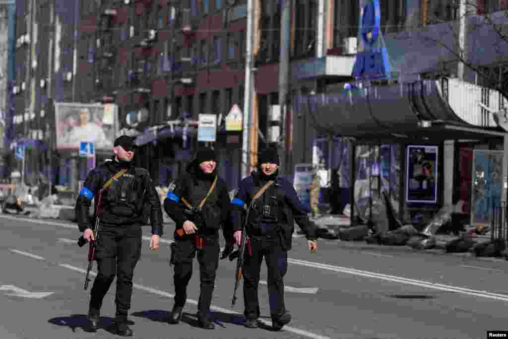 Armed police officers walk past the Artem factory in Kyiv after it was hit by shelling as Russia&#39;s attack on Ukraine continues, March 15, 2022.