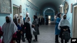 FILE - Afghan girls exit classrooms at Tajrobawai Girls High School, in Herat, Afghanistan, Nov. 25, 2021.