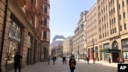 Residents walk along a nearly empty retail street in Shanghai, China, March 29, 2022. 