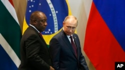 FILE - South Africa's President Cyril Ramaphosa, left, and Russia's President Vladimir Putin arrive for the Leaders Dialogue with BRICS Business Council and the New Development Bank, at the Itamaraty Palace in Brasilia, Brazil, Nov. 14, 2019.