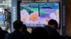 Orang-orang menonton TV yang menampilkan file gambar peluncuran rudal Korea Utara selama program berita di Stasiun Kereta Api Seoul di Seoul, Korea Selatan, 5 Maret 2022. (Foto: AP)