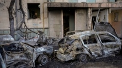 在被俄罗斯轰炸损坏的基辅一座居民楼内，一名妇女在清扫她的厨房内的瓦砾碎片。(2022年3月21日)