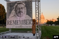 FILE - Turkish writer Hatice Cengiz, right, fiancée of Saudi journalist and dissident Jamal Khashoggi, poses next to a portrait of Khashoggi after unveiling it on the National Mall in Washington, Oct. 1, 2021