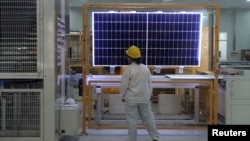 FILE - A worker conducts a quality check of a solar module at a factory in Xian, China, on Dec. 10, 2019. The European Union said on Jan. 24, 2024, that it wants to avoid over-reliance on China, which dominates in green technology production and other industries. 