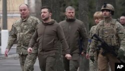FILE - President Volodymyr Zelenskyy walks to a hospital to visit patients and staff, March 13, 2022 in Kyiv.