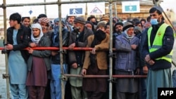 Afghan men stand in queues to receive food aid from a non-governmental organisation (NGO) in Kabul, Dec. 25, 2022. 