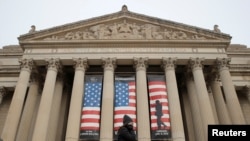 Seorang perempuan berjalan melintas di depan pintu masuk gedung Arsip Nasional (the National Archive) di tengah penghentian operasi pemerintah federal AS di Washington, 7 Januari 2019. (Foto: Jim Young)