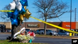 Flowers and balloons sit near the scene of a mass shooting at a Walmart, Nov. 23, 2022, in Chesapeake, Va. A Walmart manager opened fire on fellow employees in a break room of the Virginia store the night before.