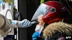 A health worker takes a swab sample from a woman to test for the COVID-19 coronavirus in the Jing'an district in Shanghai, China, on Dec. 23, 2022. 
