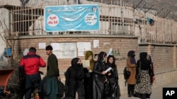 FILE - Afghan women stand outside Kabul University in Kabul, Afghanistan, on Dec. 21, 2022. The Taliban has increased restrictions on women in 2022 — including barring females from attending universities and banning women humanitarian workers — saying Islamic law mandates it.