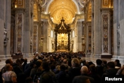 Faithful pay homage to former Pope Benedict, as his body lies in state at St. Peter's Basilica, at the Vatican, Jan. 3, 2023.