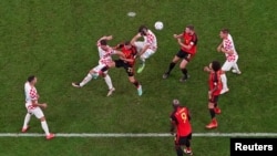 Jugadores de Croacia y Bélgica (de rojo) pujan por el dominio del baló en un partido que dio el pase a octavos de final a los croatas en la Copa del Mundo de Qatar el 1 de diciembre de 2022.