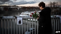 A local resident lays flowers during tribute to Mohammad Moradi, in Lyon on Dec. 27, 2022.