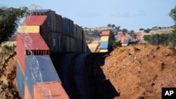 FILE - A long row of double-stacked shipping containers provides a wall between the United States and Mexico in the remote San Rafael Valley of Arizona, Dec. 8, 2022.