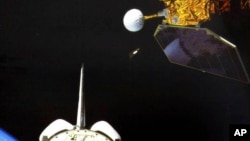 In this photo made available by NASA, the space shuttle Challenger launches the Earth Radiation Budget Satellite in 1984. The science satellite is expected to fall back to Earth on or around Jan. 8, 2023.