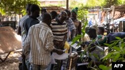 FILE - Men stand in line with their application letters to enroll as Volunteers for the Defense of the Fatherland (VDP), in Ouagadougou, Burkina Faso, Nov. 16, 2022. An attack by suspected jihadis on Dec. 8, 2022, left at least 10 people dead, most of them civilian volunteers.