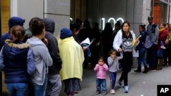 FILE - Hundreds of people overflow onto the sidewalk in a line snaking around the block outside a U.S. immigration office in San Francisco, Jan. 31, 2019.