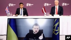 Ukrainian President Volodymyr Zelenskyy speaks via video link as Latvian Prime Minister Krisjanis Karins and British Prime Minister Rishi Sunak listen during the Joint Expeditionary Force meeting in Riga, Latvia, Dec. 19, 2022. (Henry Nicholls/Pool Photo via AP) 