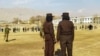 Taliban security personnel stand guard ahead of publicly flogging of women and men at a football stadium in Charikar city of Parwan province on December 8, 2022. 