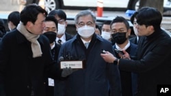 Former South Korean National Security Director Suh Hoon, center, arrives at the Seoul Central District Court in Seoul, South Korea, Dec. 2, 2022. 