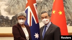 Menteri Luar Negeri Australia Penny Wong berfoto dengan mitranya dari China, Wang Yi di Beijing, China, 21 Desember 2022. (Sarah Friend/Departemen Luar Negeri dan Perdagangan Australia/Selebaran Australia via REUTERS)