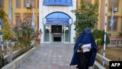 Seorang mahasiswi berjalan di depan sebuah universitas di Provinsi Kandahar pada 21 Desember 2022. (Foto: AFP)