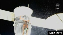 A video grab from a NASA feed obtained Dec. 15, 2022, shows liquid spraying from the aft end of the Soyuz MS-22 spacecraft, NASA said on Dec. 15, 2022. (AFP PHOTO/NASA)