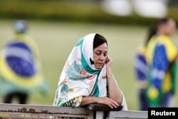 A supporter of Brazil's President Jair Bolsonaro reacts in front of the Alvorada Palace after listening to Bolsonaro on social media in Brasilia, Brazil, Dec. 30, 2022.