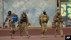 This undated photograph handed out by French military shows three Russian mercenaries, right, in northern Mali.
