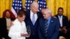 Gladys Sicknick, mother of the late U.S. Capitol Police Officer Brian Sicknick, holds the medal President Joe Biden awarded to her son, at a White House ceremony Jan. 6, 2023, marking the anniversary of the assault on the Capitol. Sicknick's father Charles is at right. 