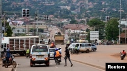 FILE - Motorists and cyclists are seen at a traffic light intersection amid the Ebola outbreak in Kampala, Uganda, Nov. 16, 2022.