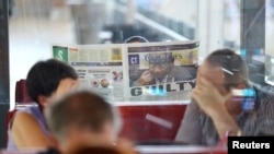 A person reads a newspaper as the future of South African President Cyril Ramaphosa hangs in the balance following the release of misconduct report in Cape Town, South Africa, Dec. 1, 2022. 