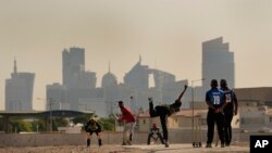 People play cricket in the streets in Doha, Qatar, Nov. 25, 2022.
